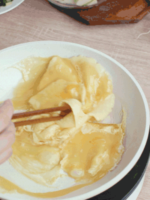 油6成熱時(shí)，下雞蛋液，邊緣凝固時(shí)翻拌成塊狀。